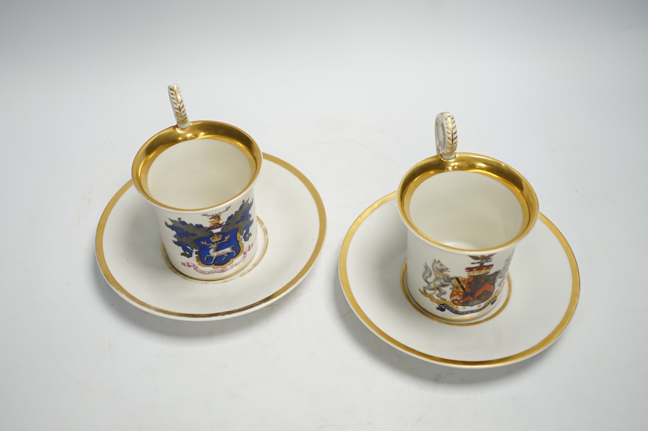 A pair of German porcelain armorial cups and saucers, one saucer reads ‘Lord Bingham s/m Y. Powell. Born 1848’